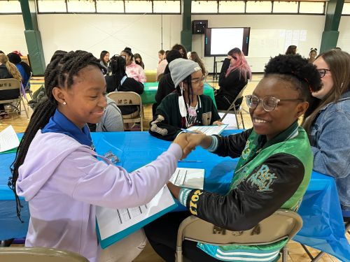 2 female students shaking hands after a mock job interview